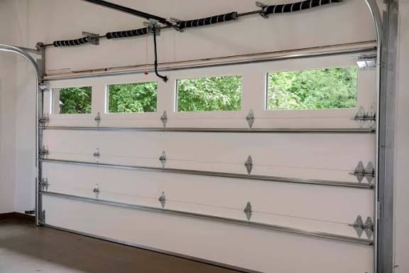 Torsion spring, shaft and opener rail above a sectional door